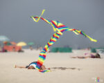 A boy letting a kite fly while lying flat on his back on Praia da Torreira in northern Portugal 1F0A7145-b_vividvista
