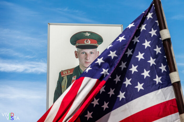 A portrait of an American soldier behind the Star Spangled Banner at Check Point Charlie in Berlin 1F0A8510_vividvista
