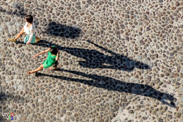 Two Women cast long Shadows in Coimbra, Portugal