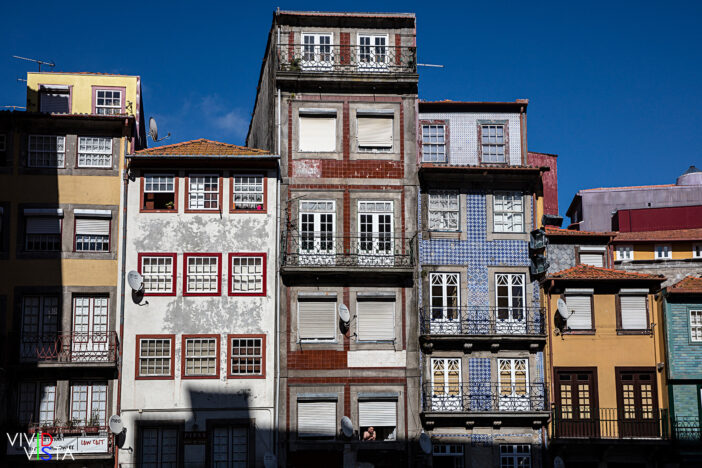 A man enjoys the Sun reaching his window in Ribeira, Porto, Portugal